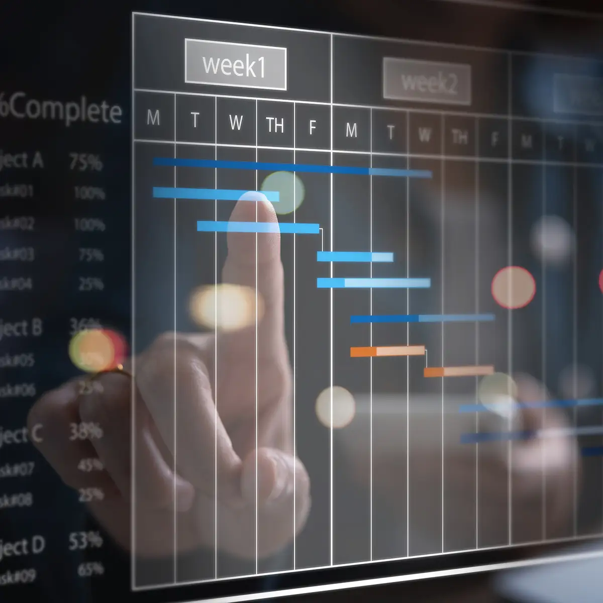 A close-up of a person interacting with a digital project management interface, focusing on a Gantt chart displayed on a transparent screen. The chart outlines tasks and timelines across weeks, with various coloured bars indicating progress on different projects. The person’s finger is seen pointing at a task bar, suggesting active engagement in managing deadlines and project timelines.